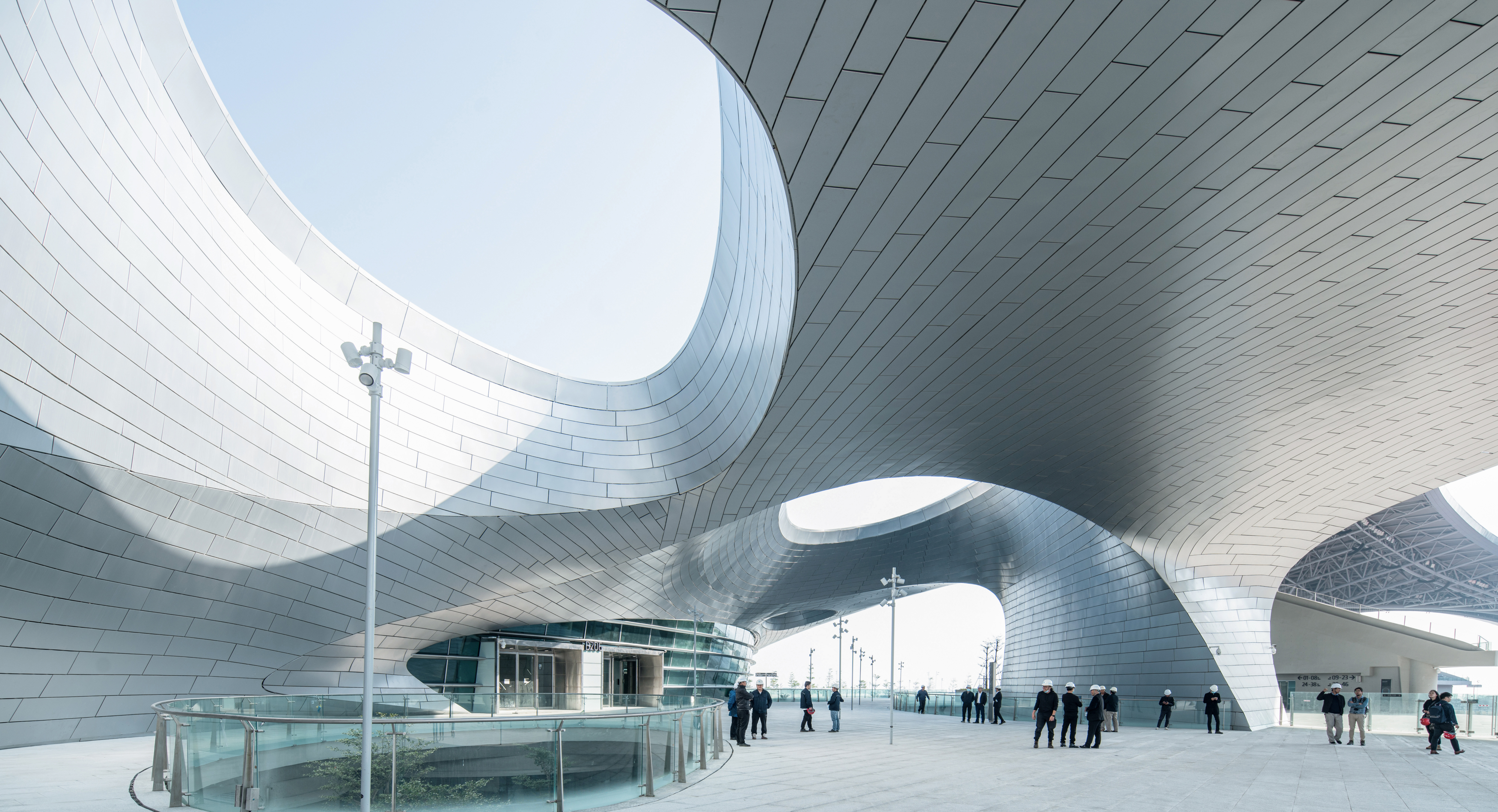 Interior view showing the flowing roof form continuing into an enclosed public space.