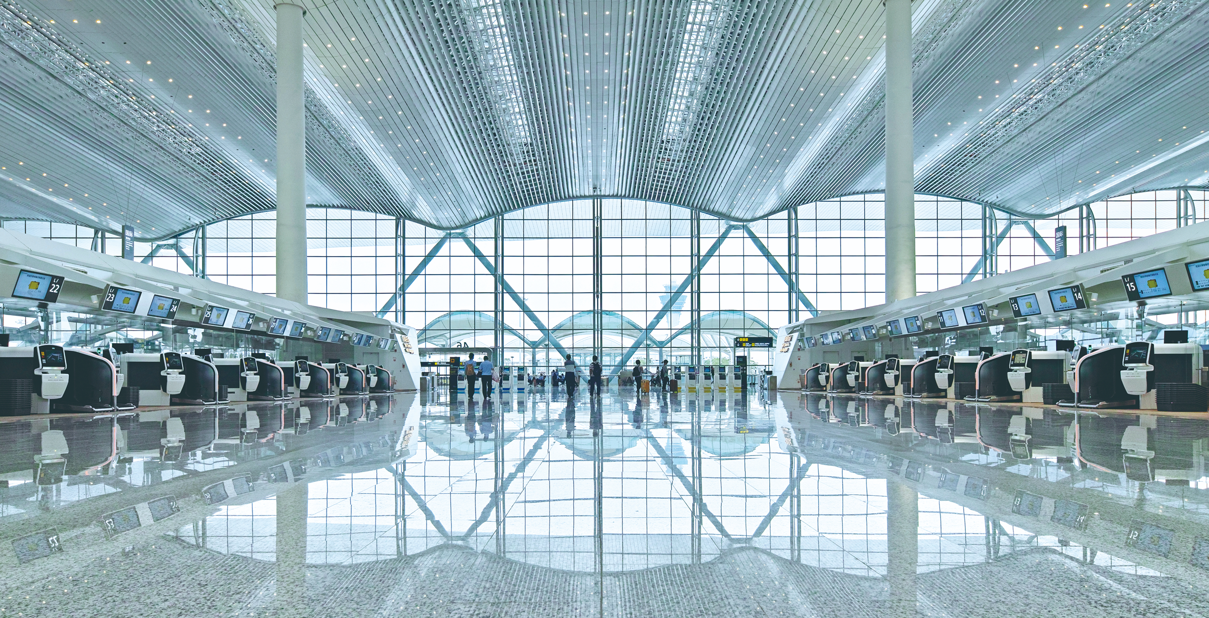 Departure hall interior showing the large public space, ceiling rhythm and check-in environment.