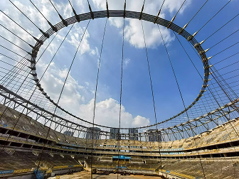 Construction site view showing the stadium roof structure during build.
