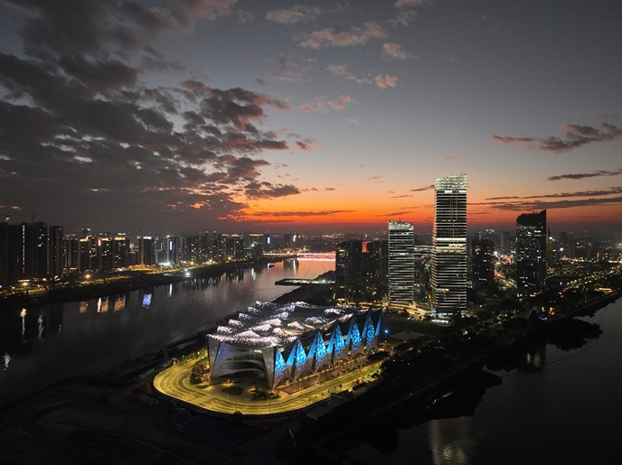 Night aerial view of the Great Bay Area Science Hall illuminated against the Nansha waterfront and city lights.