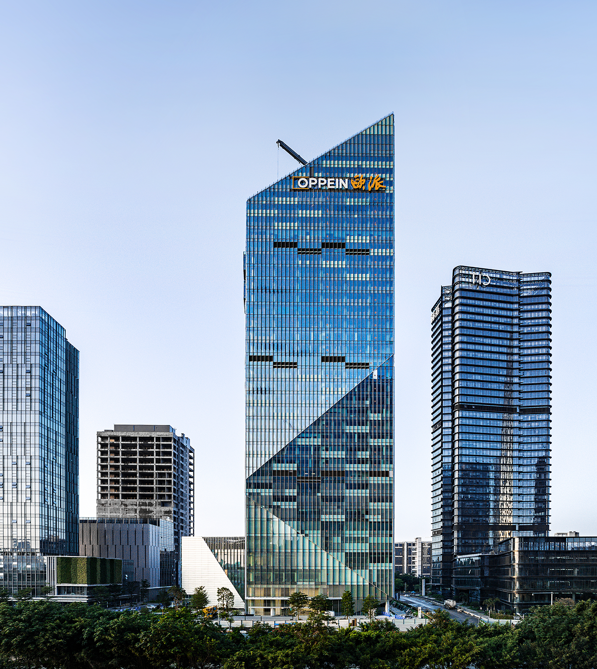 Daytime view of the Oppein Headquarters tower showing its diamond-cut facade against the Guangzhou skyline.