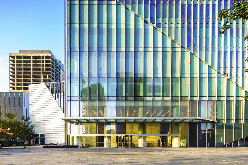 Ground level view of the building entrance showing material and facade detail quality.