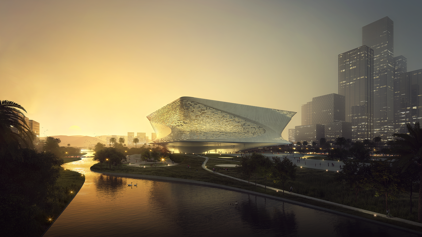 Night view of the exhibition hall beside a river, showing the illuminated building and surrounding landscaped path.